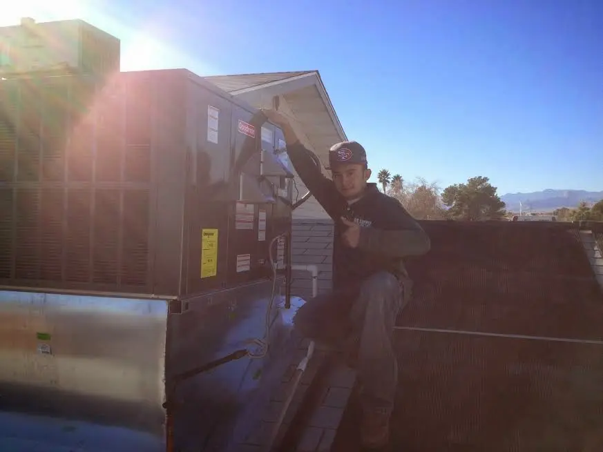 HVAC technician performing Air Duct Repair on a rooftop unit in Hanover