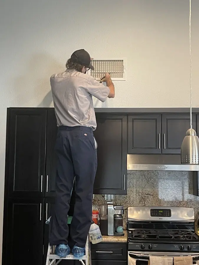 Technician inspecting an air vent during HVAC service in Hanover